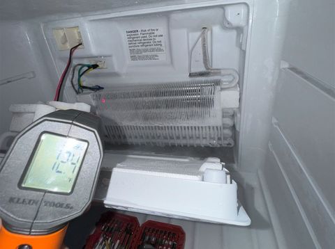 Infrared thermometer checking a freezer evaporator